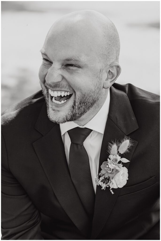 groom laughing to side of camera at Pike Lake wedding