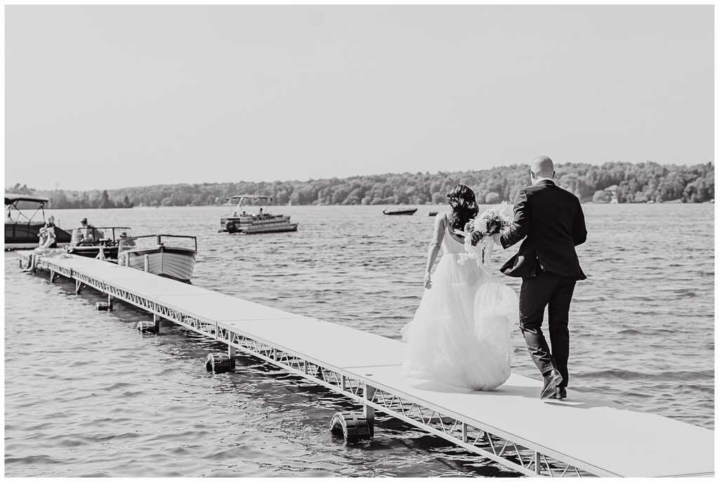 bride and groom walking down dock at Pike Lake wedding