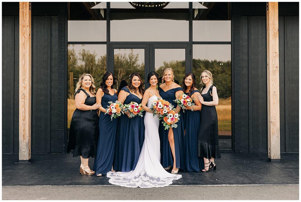 bridesmaids in black dresses smiling at camera