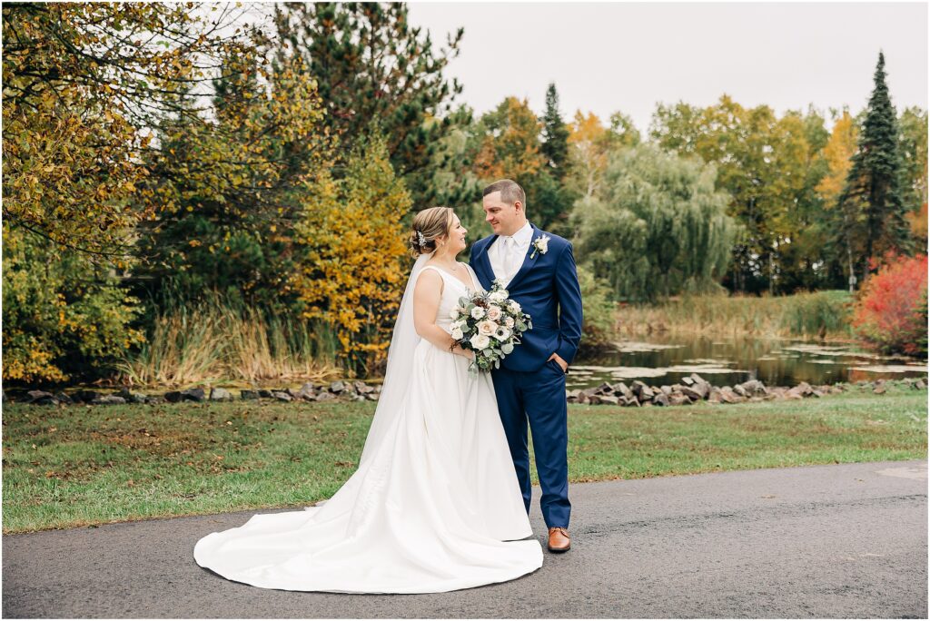 bride and groom in front of fall colors at the Minnesota Discovery Center
